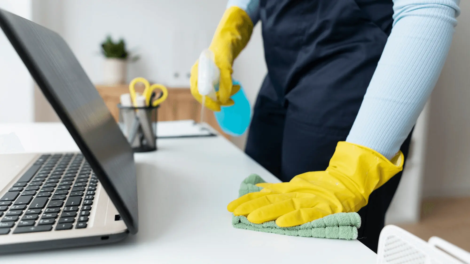Professional cleaning a desk workspace