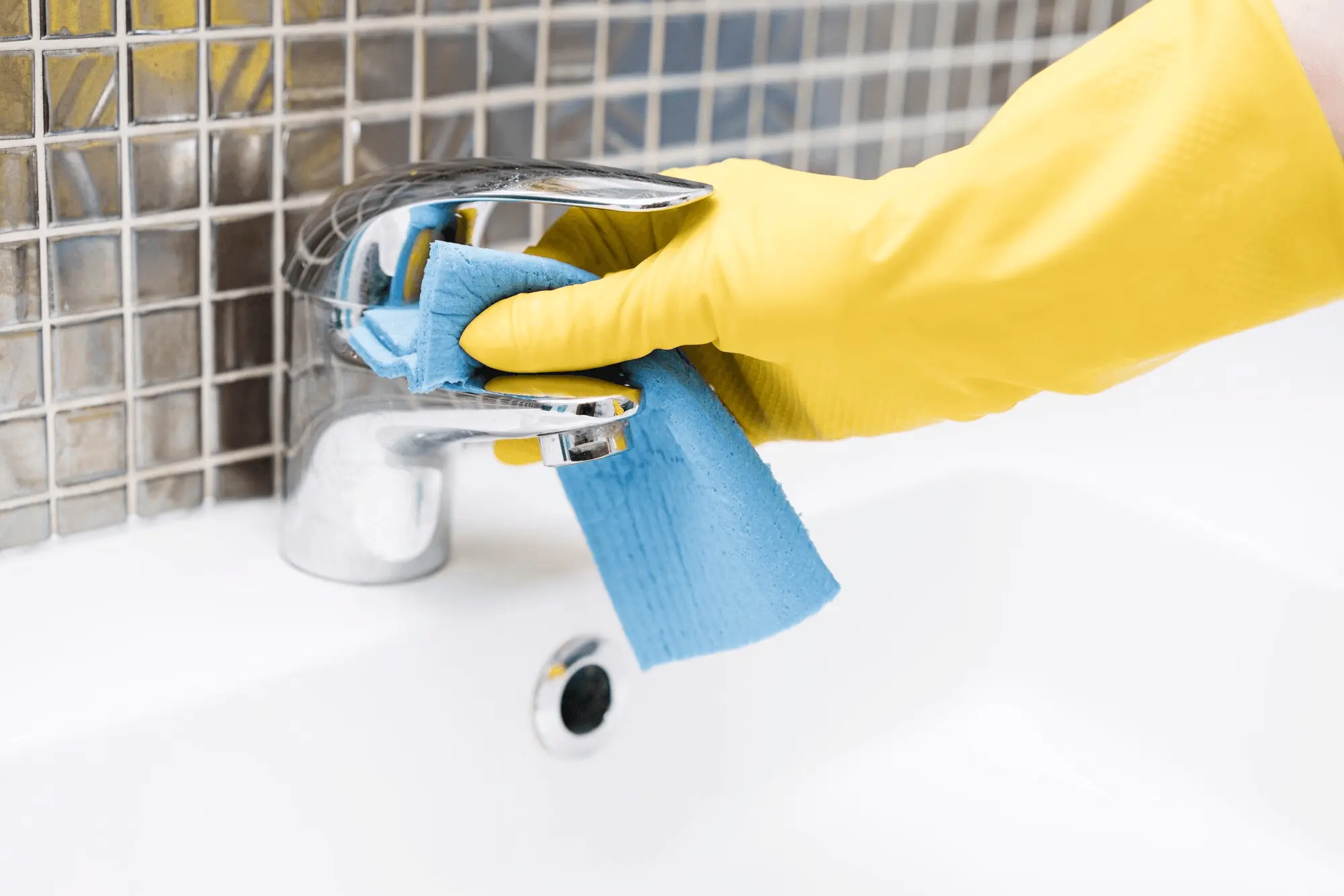 Professional cleaning a tap and sink